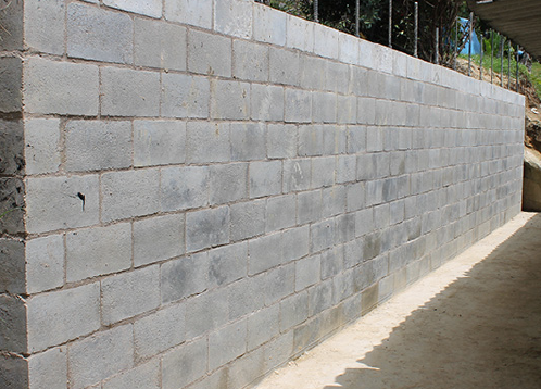 Sistema y método de construcción de una pared para muros de contención en mampostería postensada con elementos no adheridos